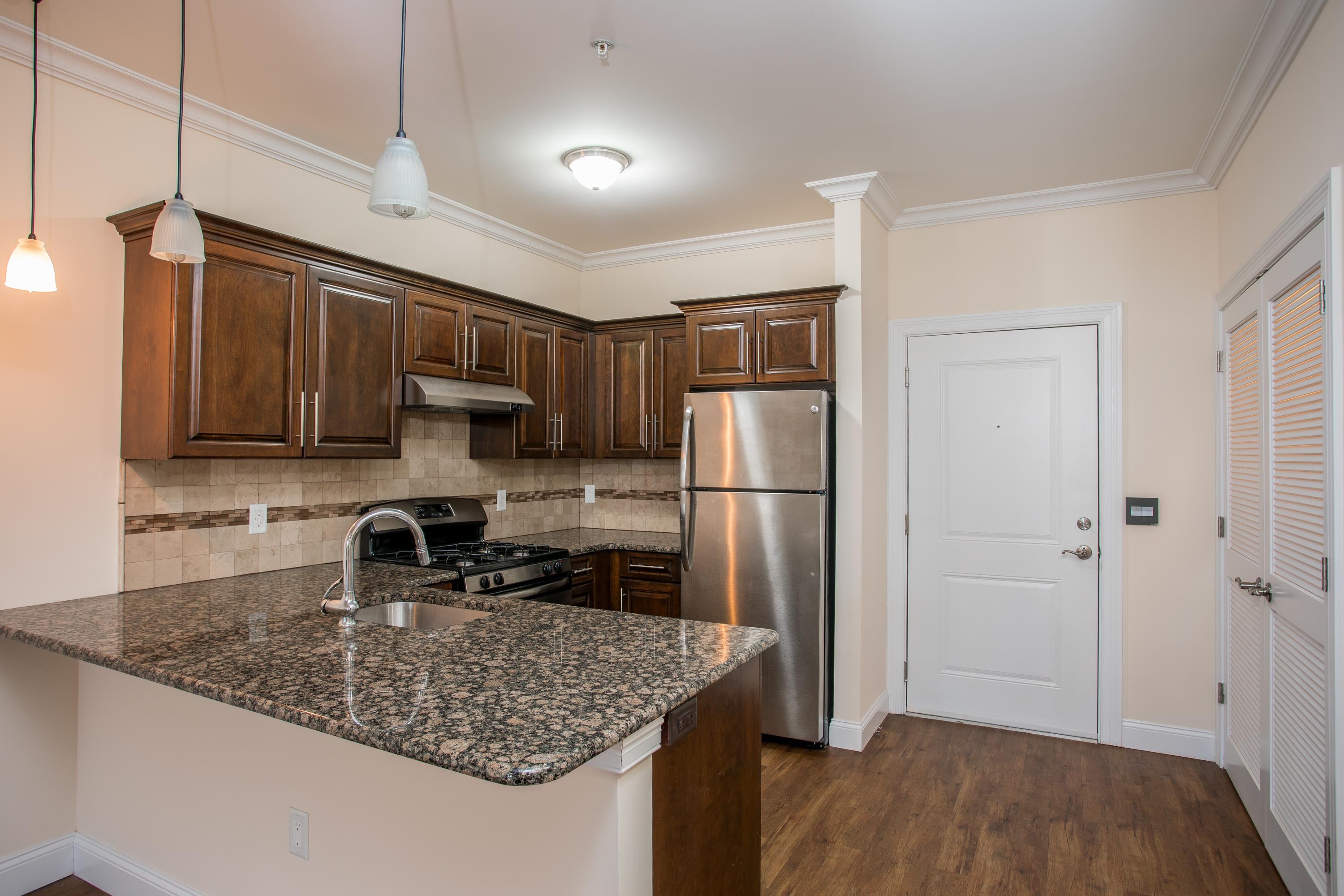 6111 Fillmore Place, Unit 306 West New York, NJ 07093 - Photo 10 of 27 a kitchen with stainless steel appliances granite countertop a refrigerator a stove a sink and a microwave