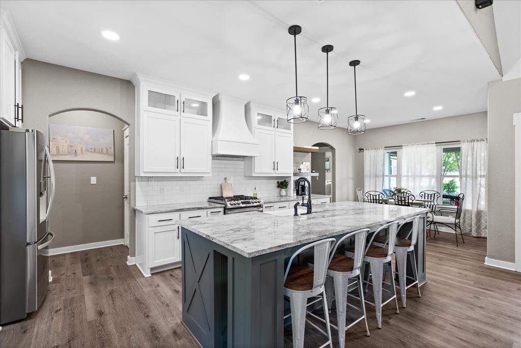 710 Valek Road Ennis, TX 75119 - Photo 14 of 40 a kitchen with stainless steel appliances granite countertop a kitchen island hardwood floor and a sink