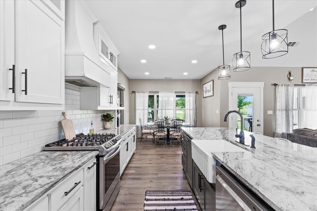 710 Valek Road Ennis, TX 75119 - Photo 16 of 40 a kitchen with sink stove and cabinets