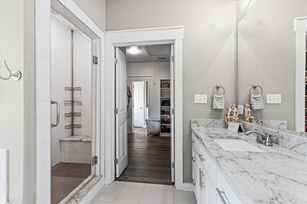 710 Valek Road Ennis, TX 75119 - Photo 26 of 40 a bathroom with a granite countertop sink mirror and shower