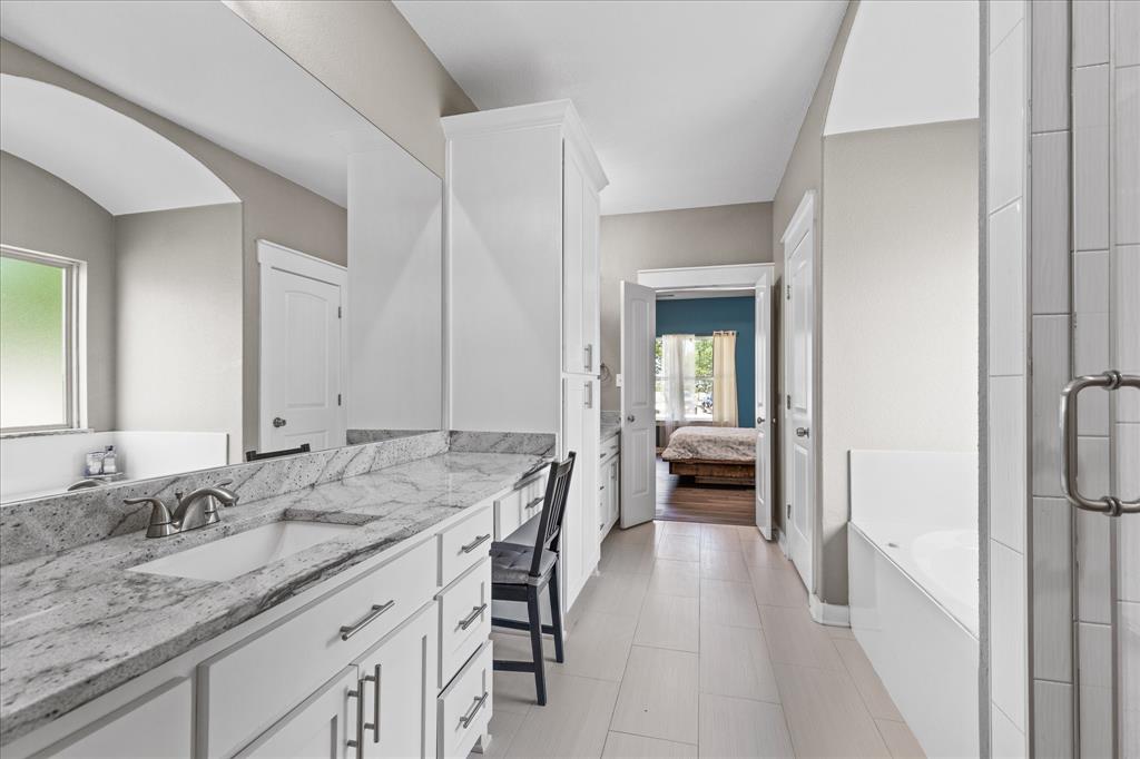 710 Valek Road Ennis, TX 75119 - Photo 27 of 40 a en suite bathroom with a granite countertop sink and a large mirror