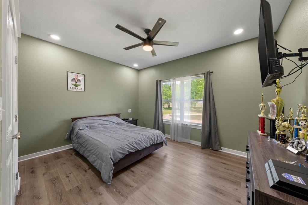 710 Valek Road Ennis, TX 75119 - Photo 28 of 40 a bedroom with a bed and a chandelier