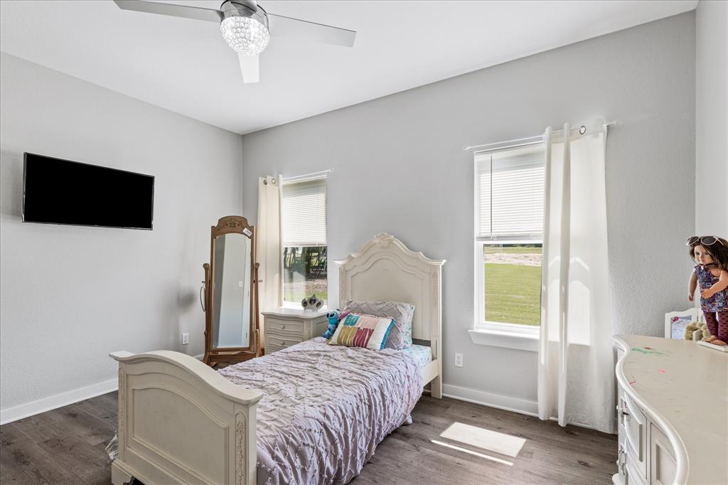 710 Valek Road Ennis, TX 75119 - Photo 31 of 40 a bedroom with a bed and a flat screen tv