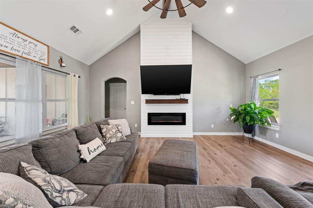 710 Valek Road Ennis, TX 75119 - Photo 10 of 40 a living room with furniture a fireplace and a flat screen tv