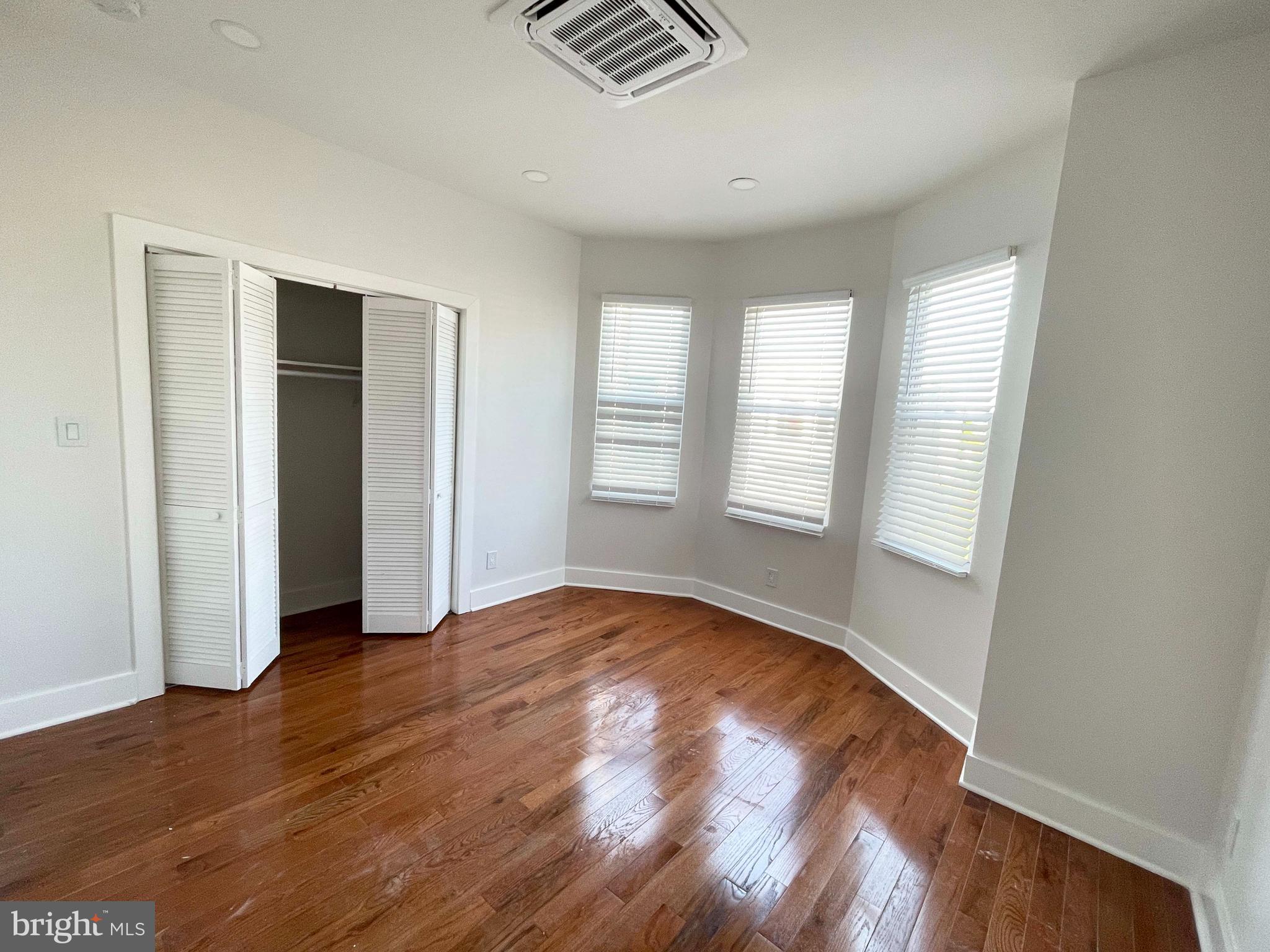 309 South 60th Street, Unit 1 Philadelphia, PA 19143 - Photo 2 of 17 an empty room with wooden floor and windows