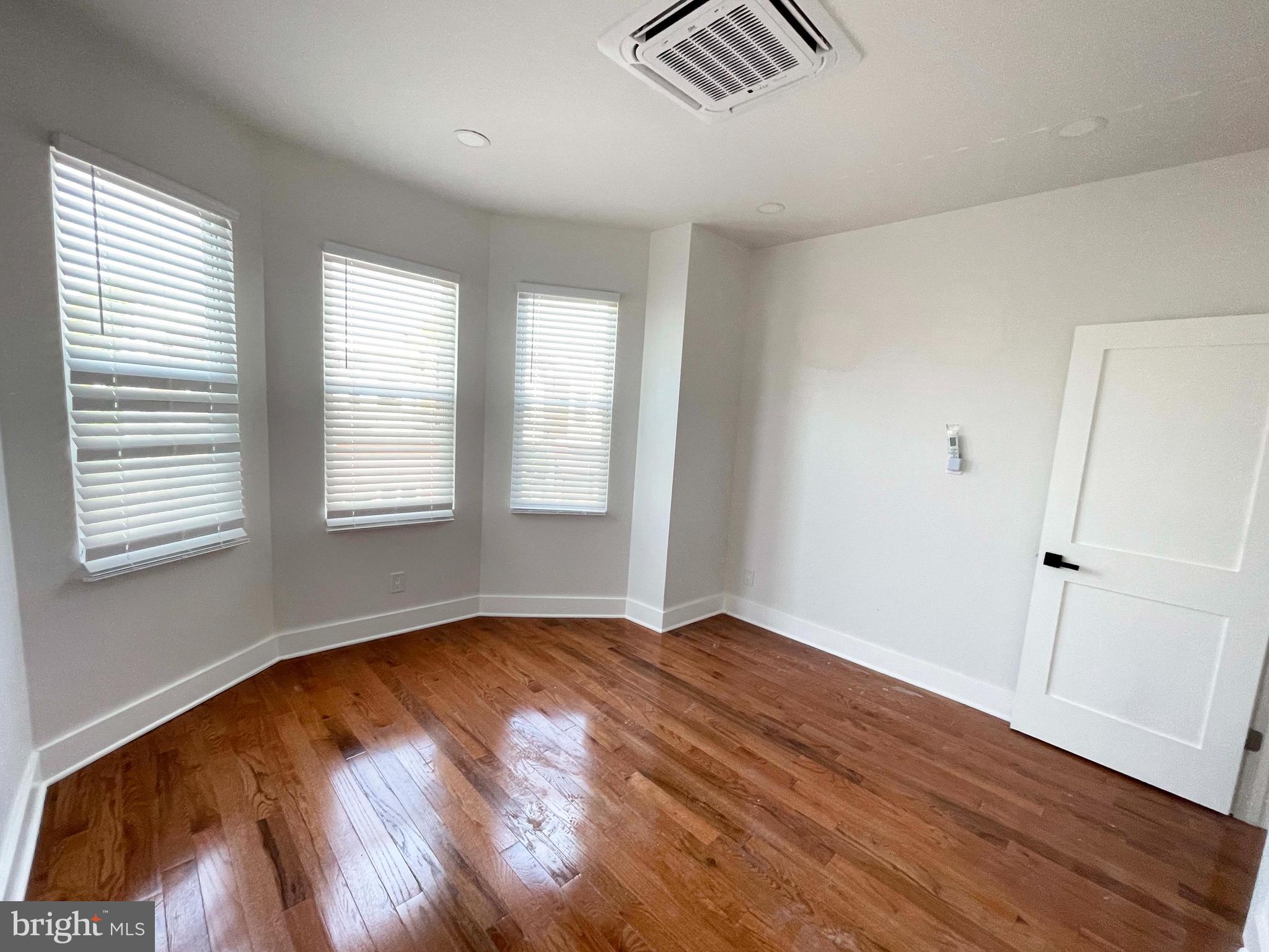 309 South 60th Street, Unit 1 Philadelphia, PA 19143 - Photo 3 of 17 wooden floor in an empty room with a window