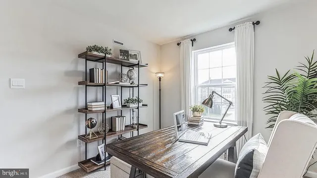 a view of a workspace with furniture and a window