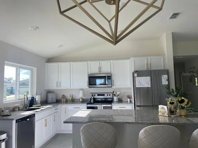 a kitchen with stainless steel appliances granite countertop a stove refrigerator sink and cabinets