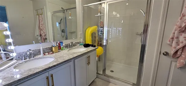 a bathroom with a granite countertop sink a mirror a shower and a bathtub