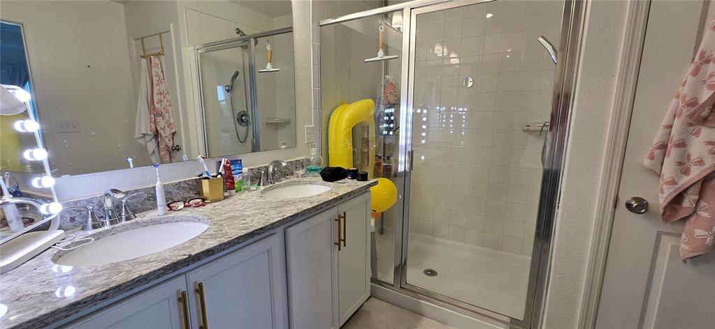 1446 Geranium Drive Mascotte, FL 34753 - Photo 10 of 24 a bathroom with a granite countertop sink a mirror a shower and a bathtub