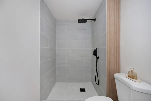 a bathroom with a granite countertop shower a toilet and a sink