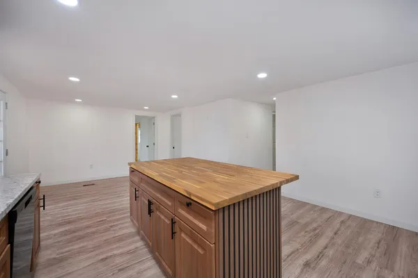 a kitchen with a stove and wooden floor