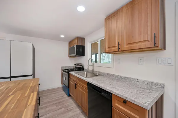 a kitchen with stainless steel appliances granite countertop a sink stove and refrigerator