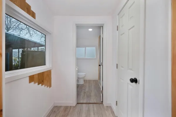 a view of a hallway with wooden floor and closet area