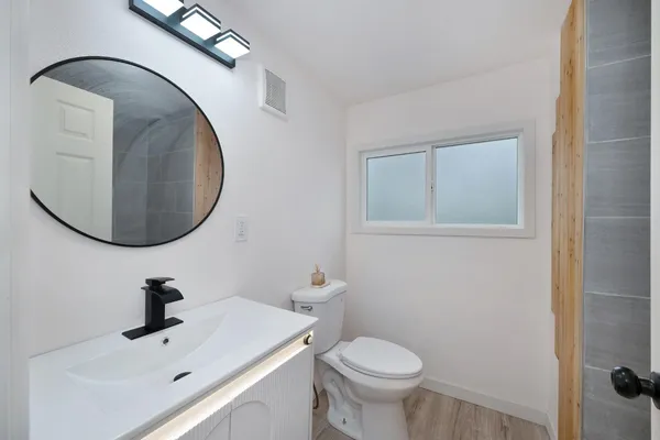 a bathroom with a sink mirror and toilet