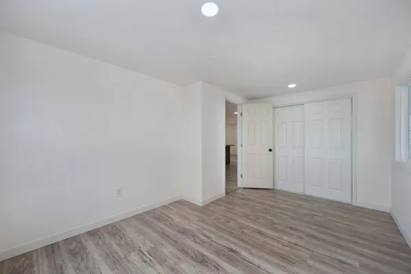 a view of an empty room with wooden floor