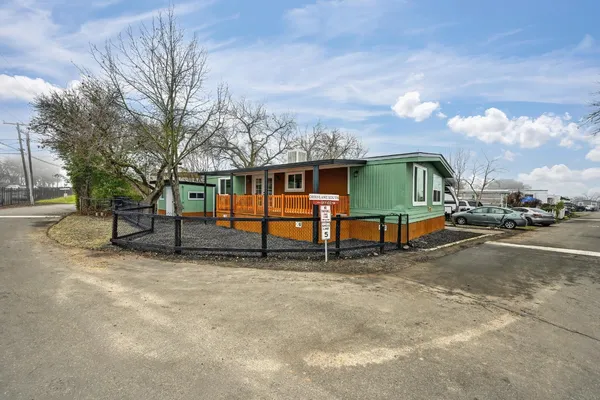 a view of a house with a yard and fence
