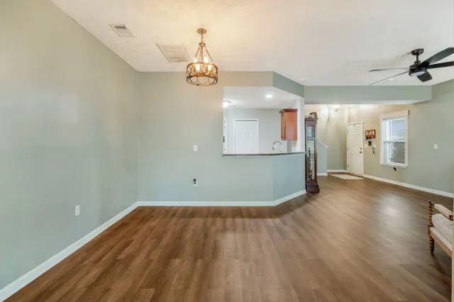 a kitchen with stainless steel appliances granite countertop a sink and cabinets with wooden floor