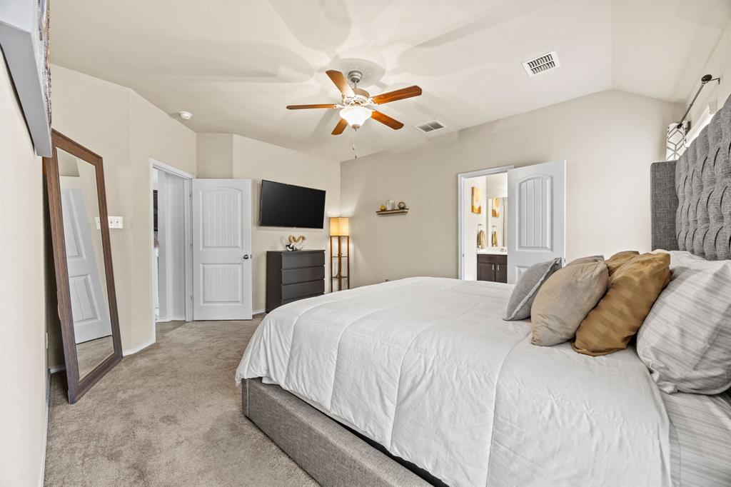 3010 Rosemount Lane Forney, TX 75126 - Photo 15 of 33 a bedroom with a large bed a flat tv screen and a ceiling fan