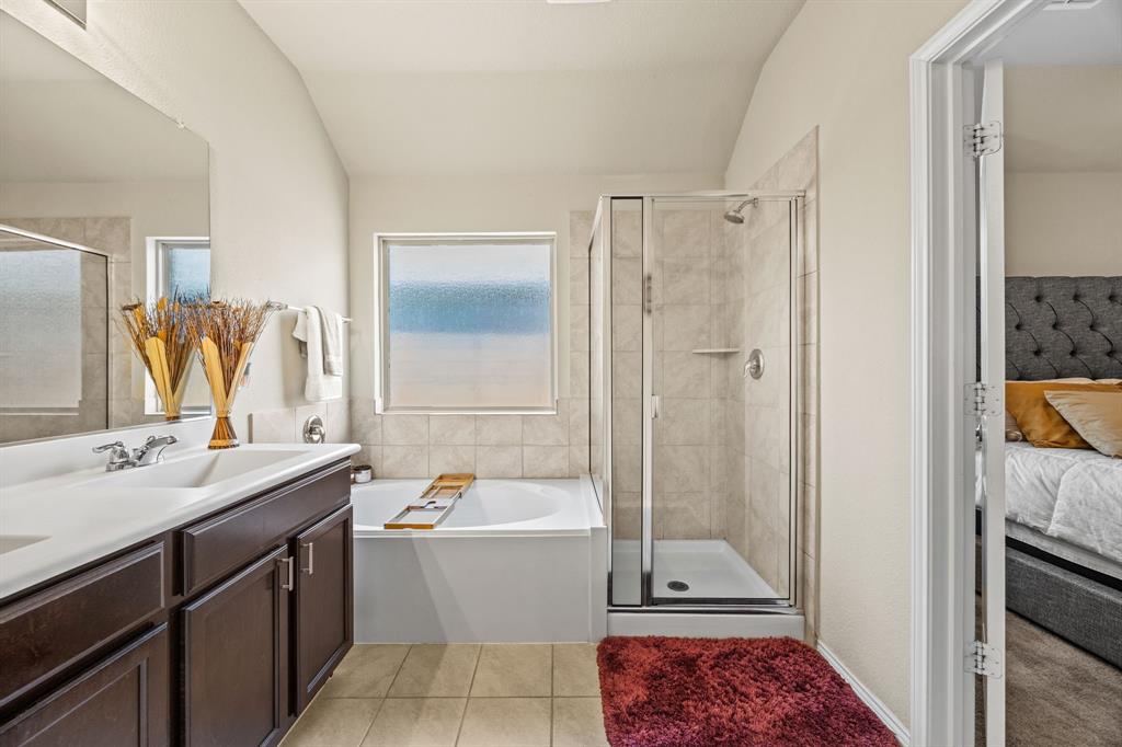 3010 Rosemount Lane Forney, TX 75126 - Photo 16 of 33 a bathroom with a tub sink vanity and a mirror