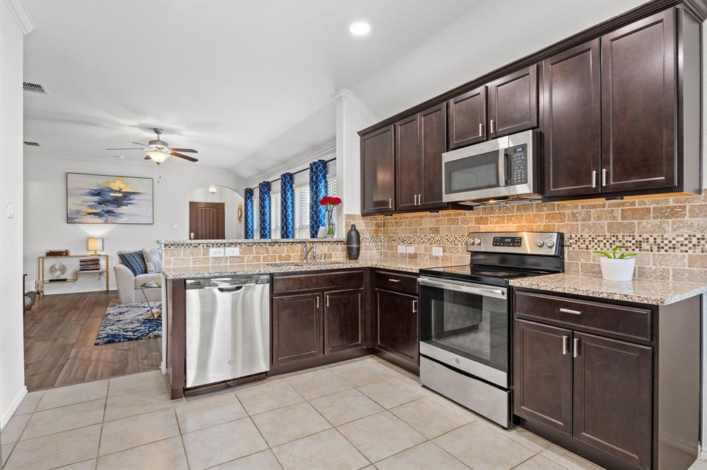 3010 Rosemount Lane Forney, TX 75126 - Photo 3 of 33 a kitchen with stainless steel appliances granite countertop a stove cabinets and entryway