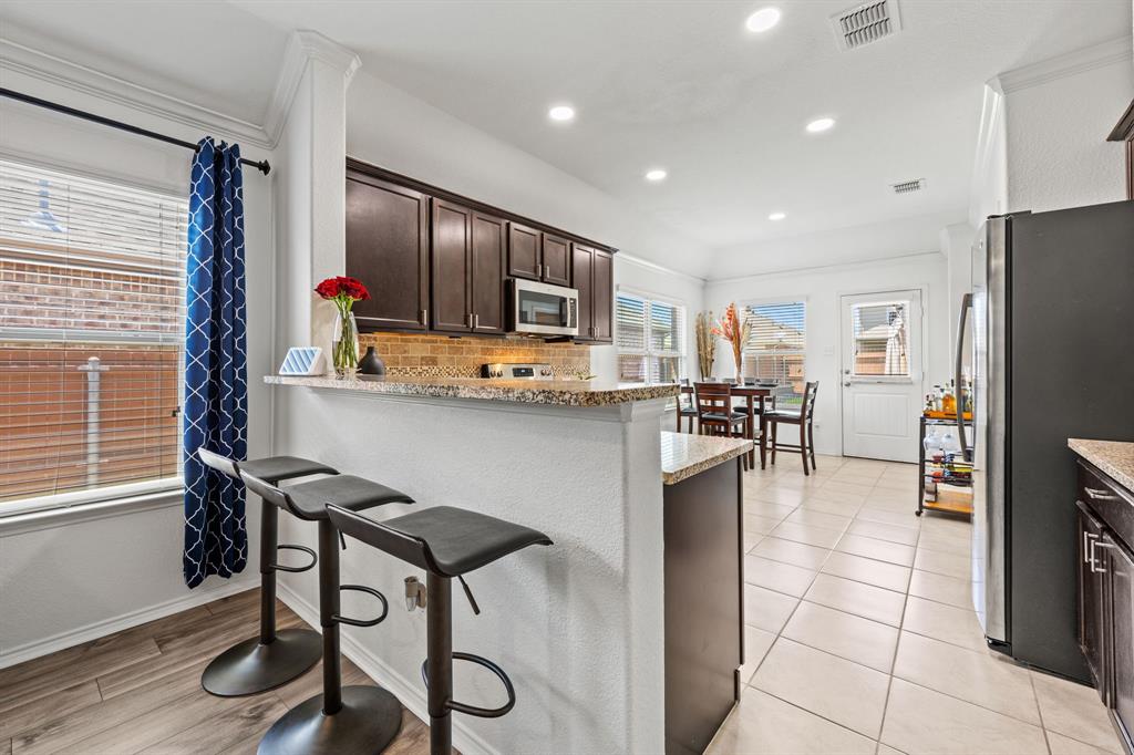 3010 Rosemount Lane Forney, TX 75126 - Photo 8 of 33 a kitchen with stainless steel appliances kitchen island granite countertop a refrigerator and a stove top oven