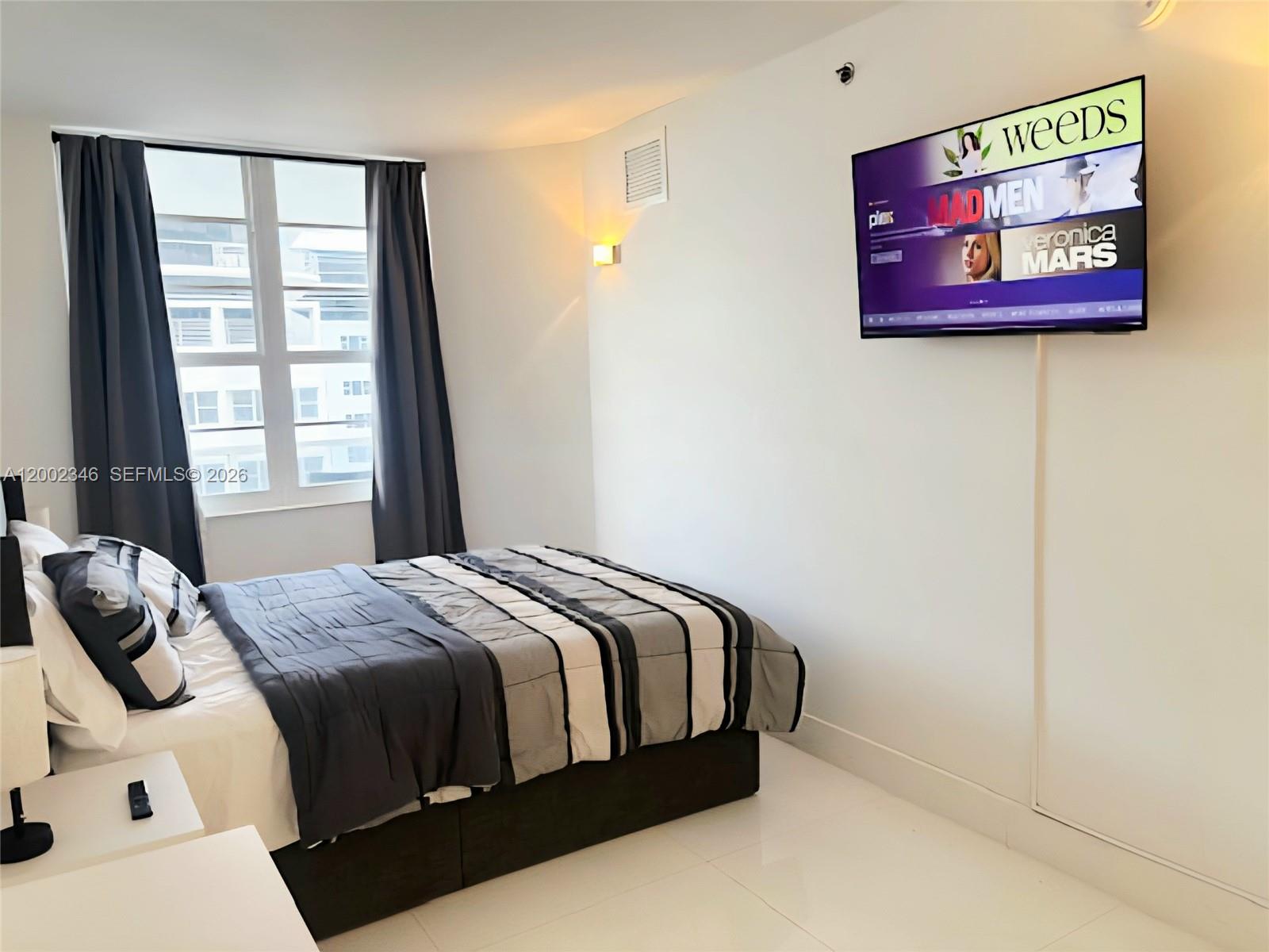100 Lincoln Road, Unit 927 Miami Beach, FL 33139 - Photo 13 of 42 a bedroom with a bed and a window