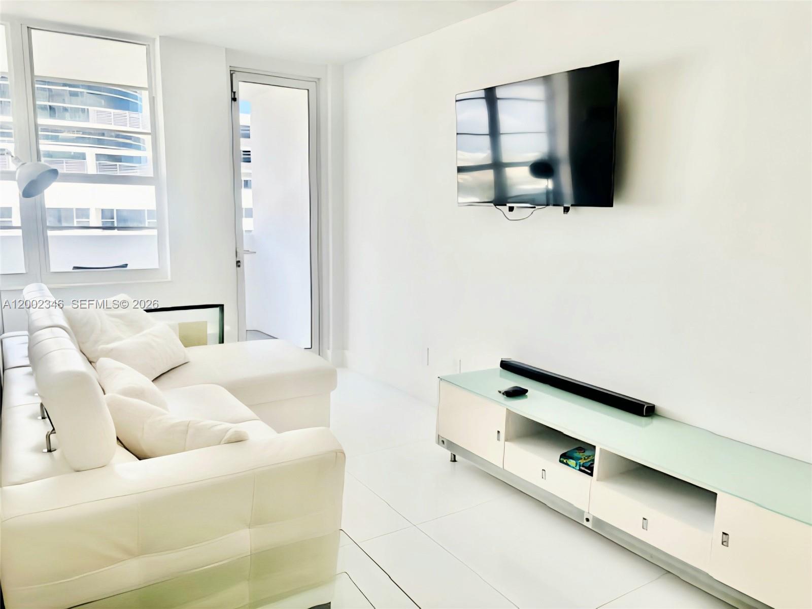 100 Lincoln Road, Unit 927 Miami Beach, FL 33139 - Photo 2 of 42 a living room with a bed furniture and a window