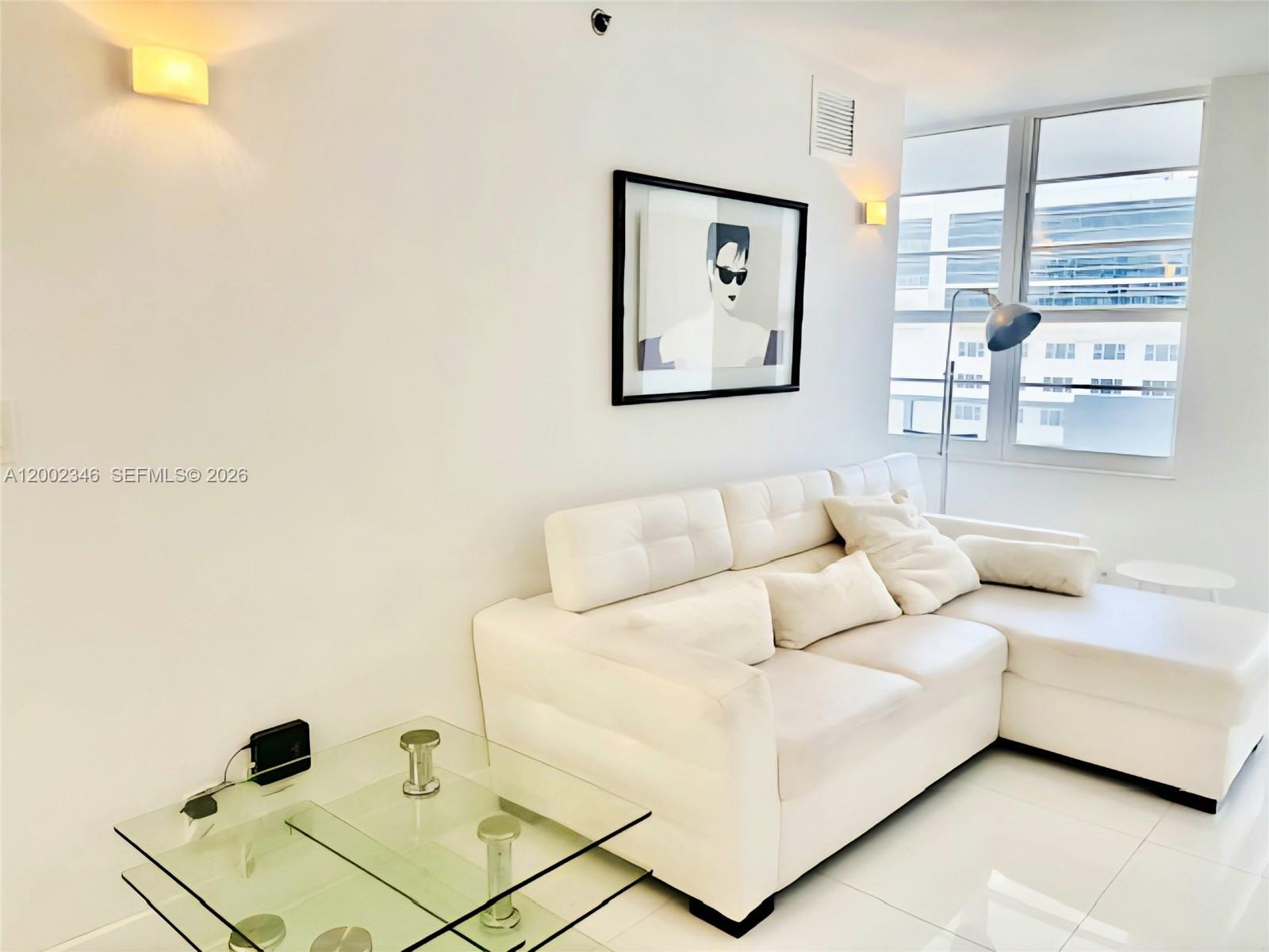 100 Lincoln Road, Unit 927 Miami Beach, FL 33139 - Photo 4 of 42 a living room with a couch and a window