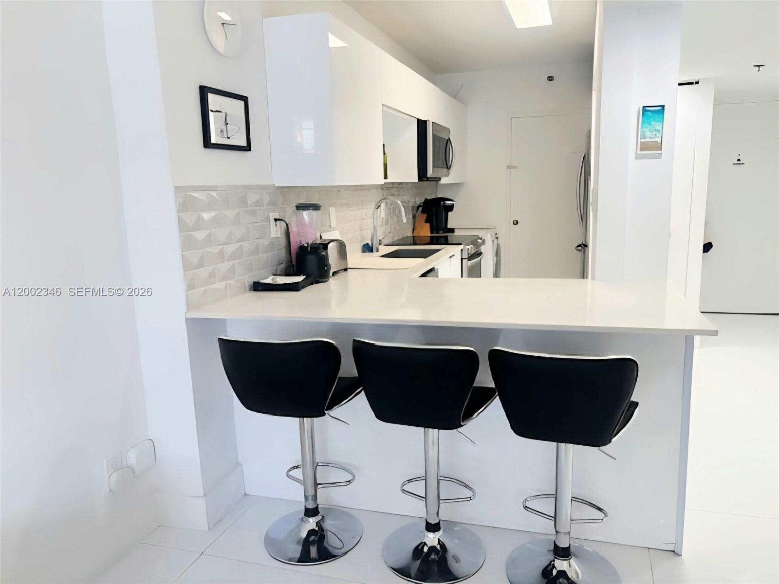 100 Lincoln Road, Unit 927 Miami Beach, FL 33139 - Photo 5 of 42 a kitchen with a sink cabinets and chair