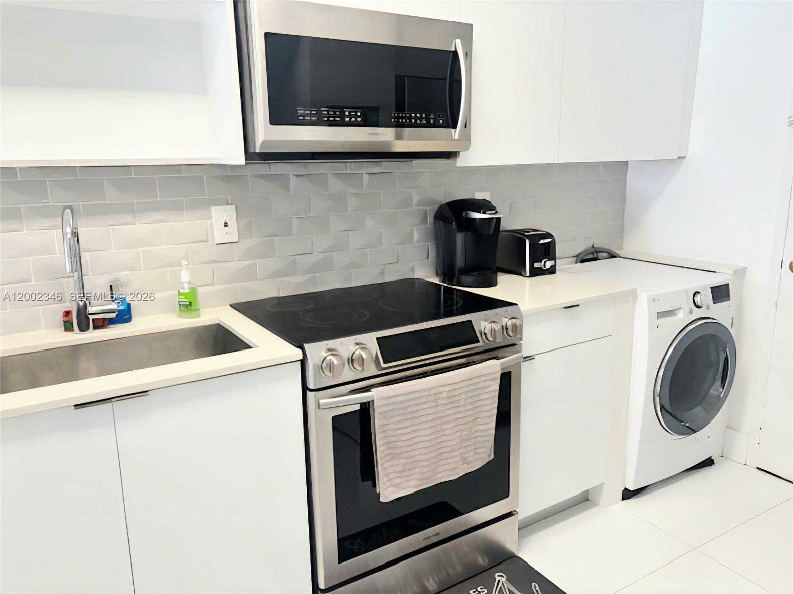 100 Lincoln Road, Unit 927 Miami Beach, FL 33139 - Photo 6 of 42 a utility room with sink washer and dryer