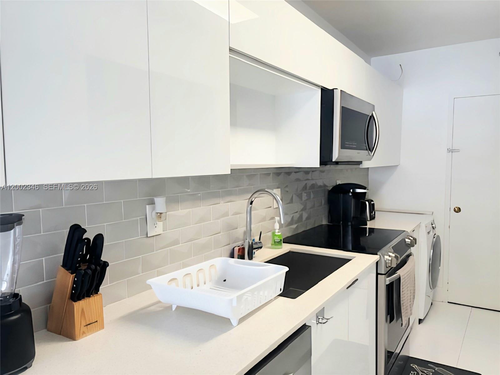 100 Lincoln Road, Unit 927 Miami Beach, FL 33139 - Photo 8 of 42 a kitchen with a sink and a stove top oven