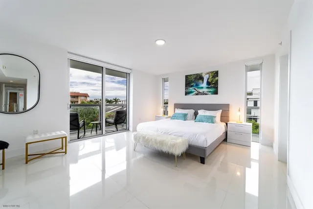 a spacious bedroom with a bed couch and a large window