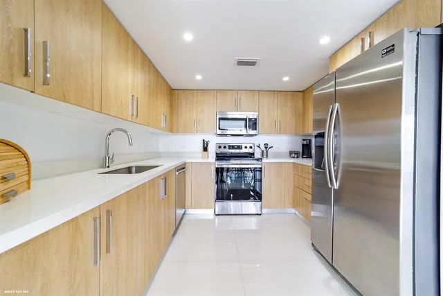 a kitchen with stainless steel appliances granite countertop a refrigerator and a sink