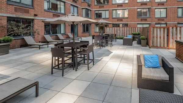 a view of a patio with couches table and chairs and potted plants