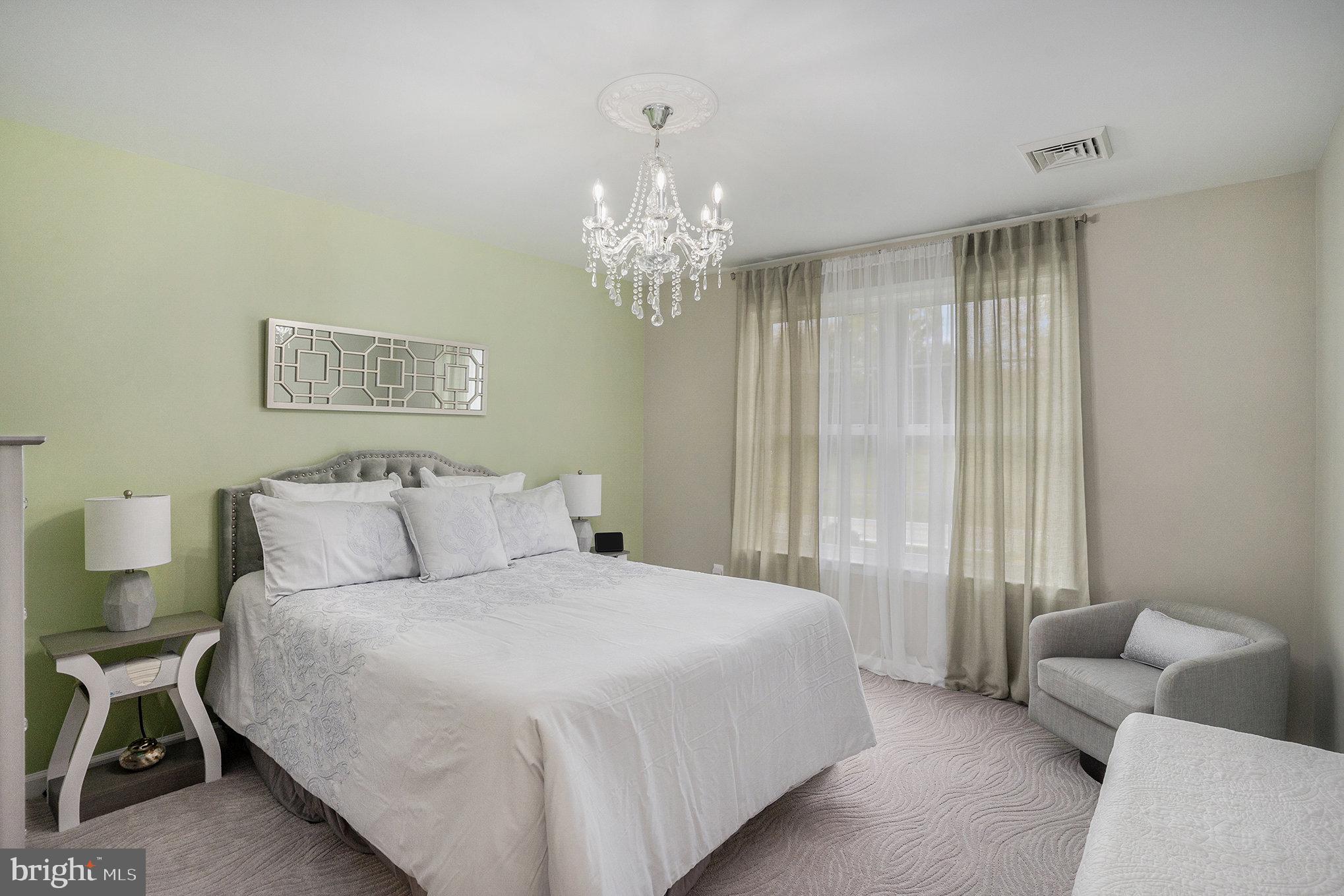 472 Evansburg Road Collegeville, PA 19426 - Photo 30 of 48 a spacious bedroom with a bed and a chandelier