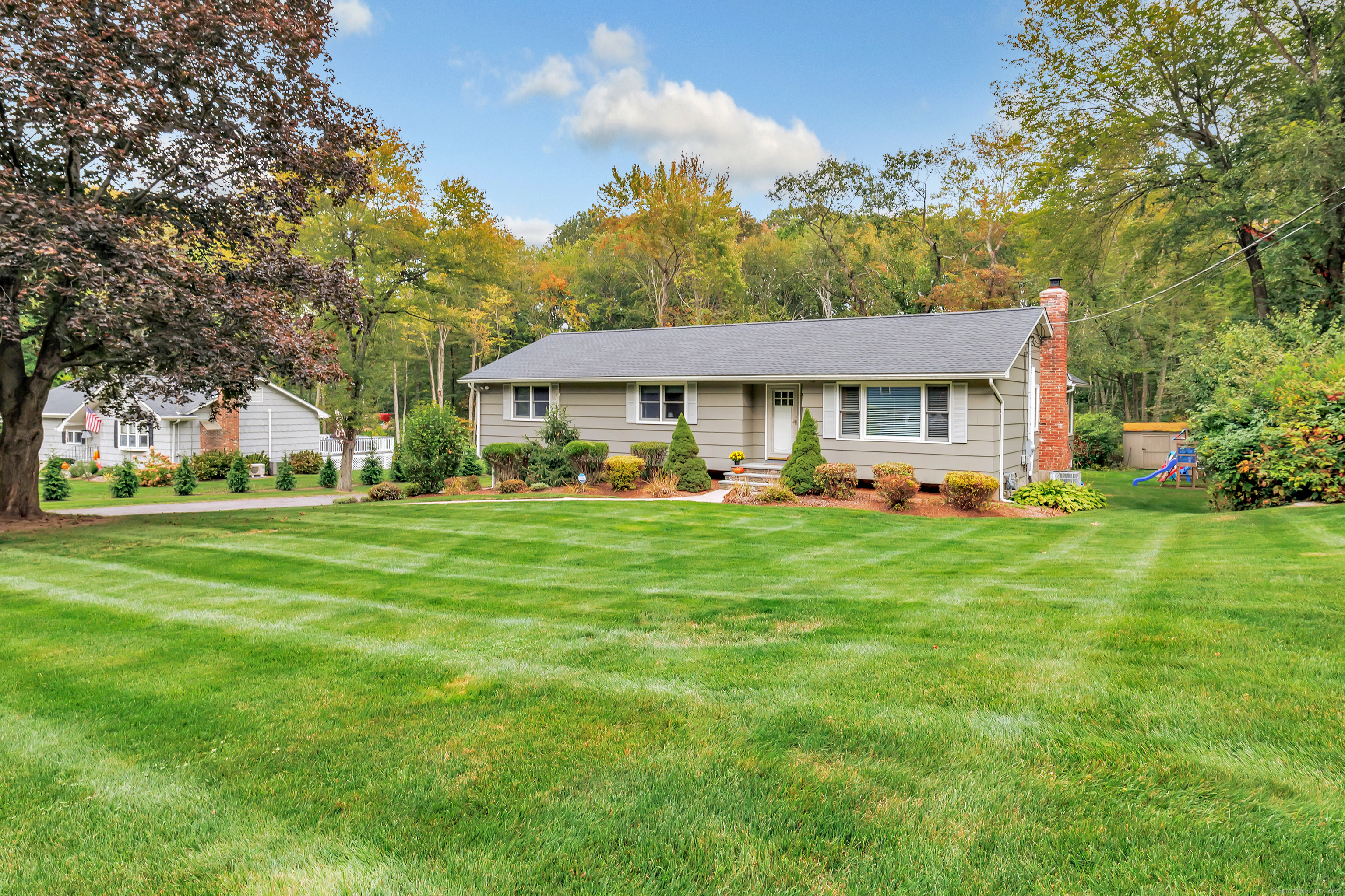 a front view of a house with a yard table and trees