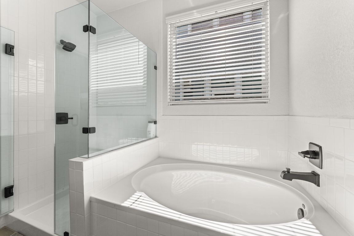 8512 McKamy Drive Austin, TX 78744 - Photo 16 of 28 The spa-inspired bath features a soaking tub and frameless walk-in shower.