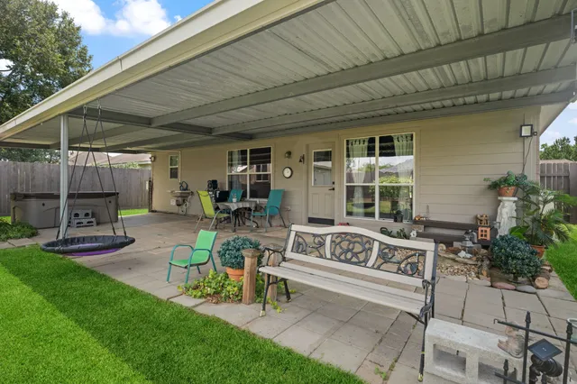 a view of a patio with table and chairs potted plants and large tree