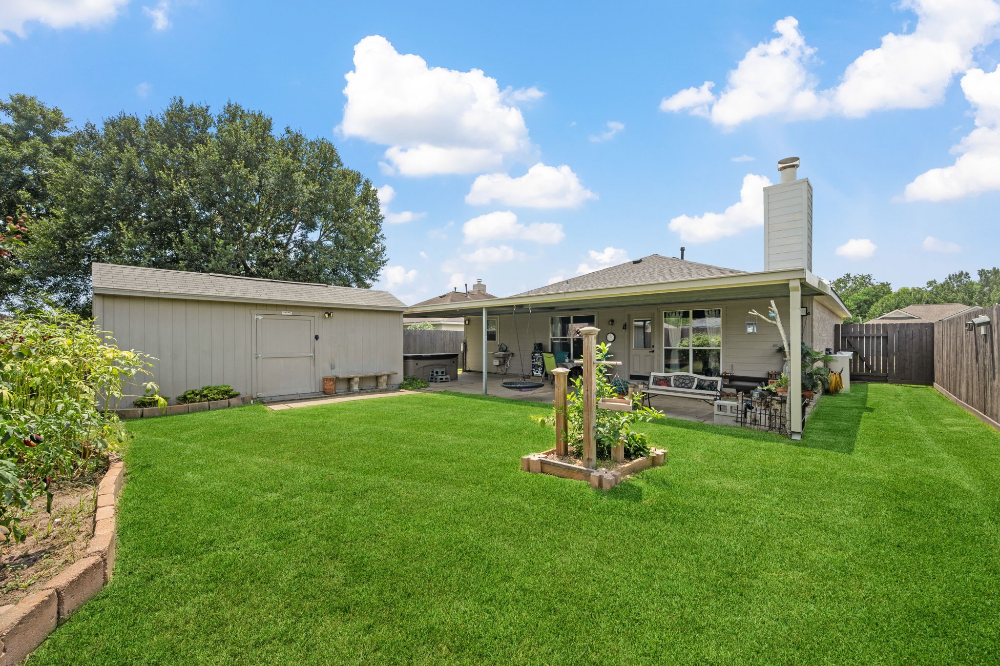 3330 Red Cedar Drive Baytown, TX 77521 - Photo 24 of 25 a view of a backyard with table and chairs a barbeque and wooden fence