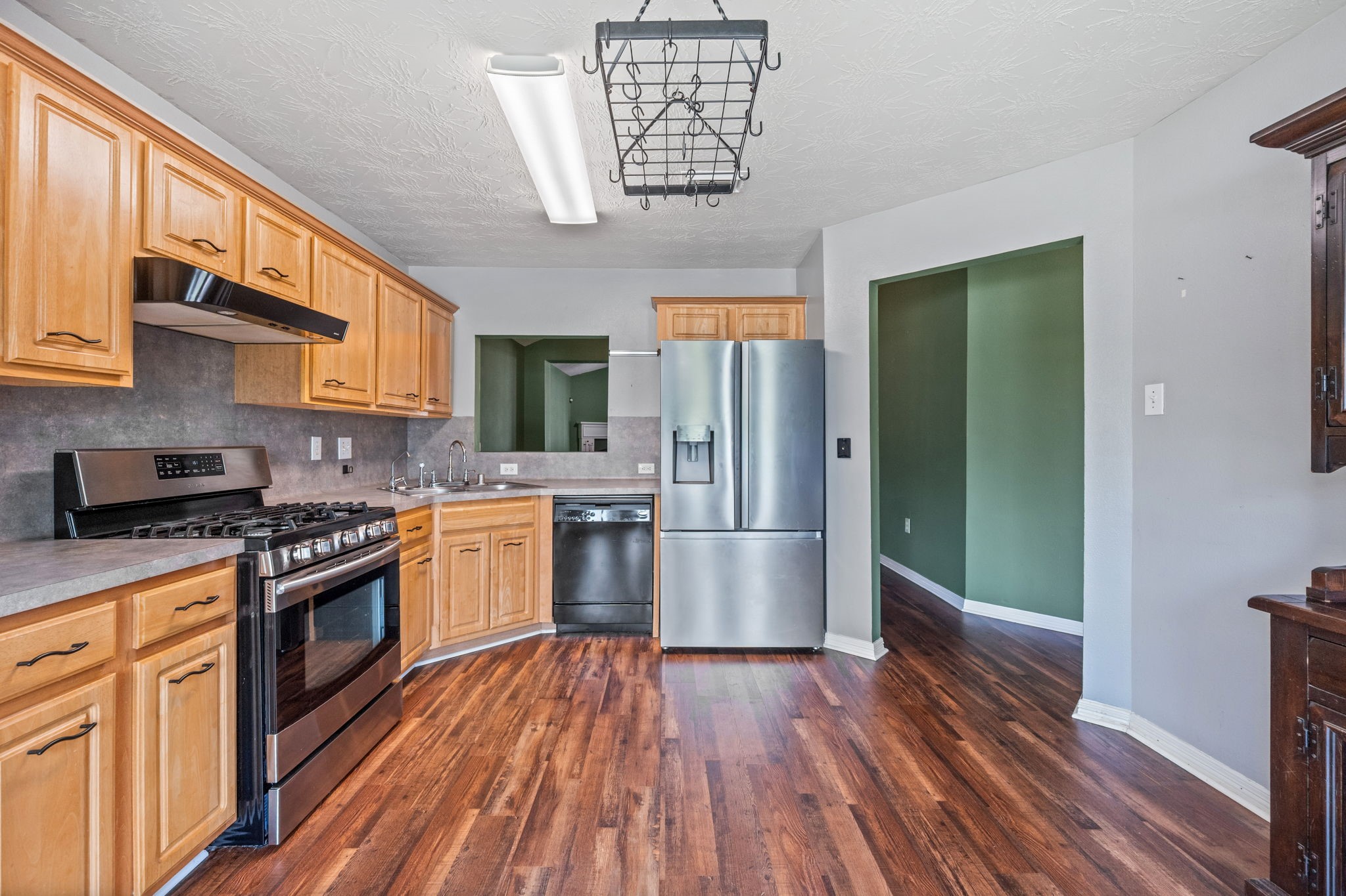 3330 Red Cedar Drive Baytown, TX 77521 - Photo 8 of 25 a kitchen with granite countertop wooden floors a stove and a refrigerator