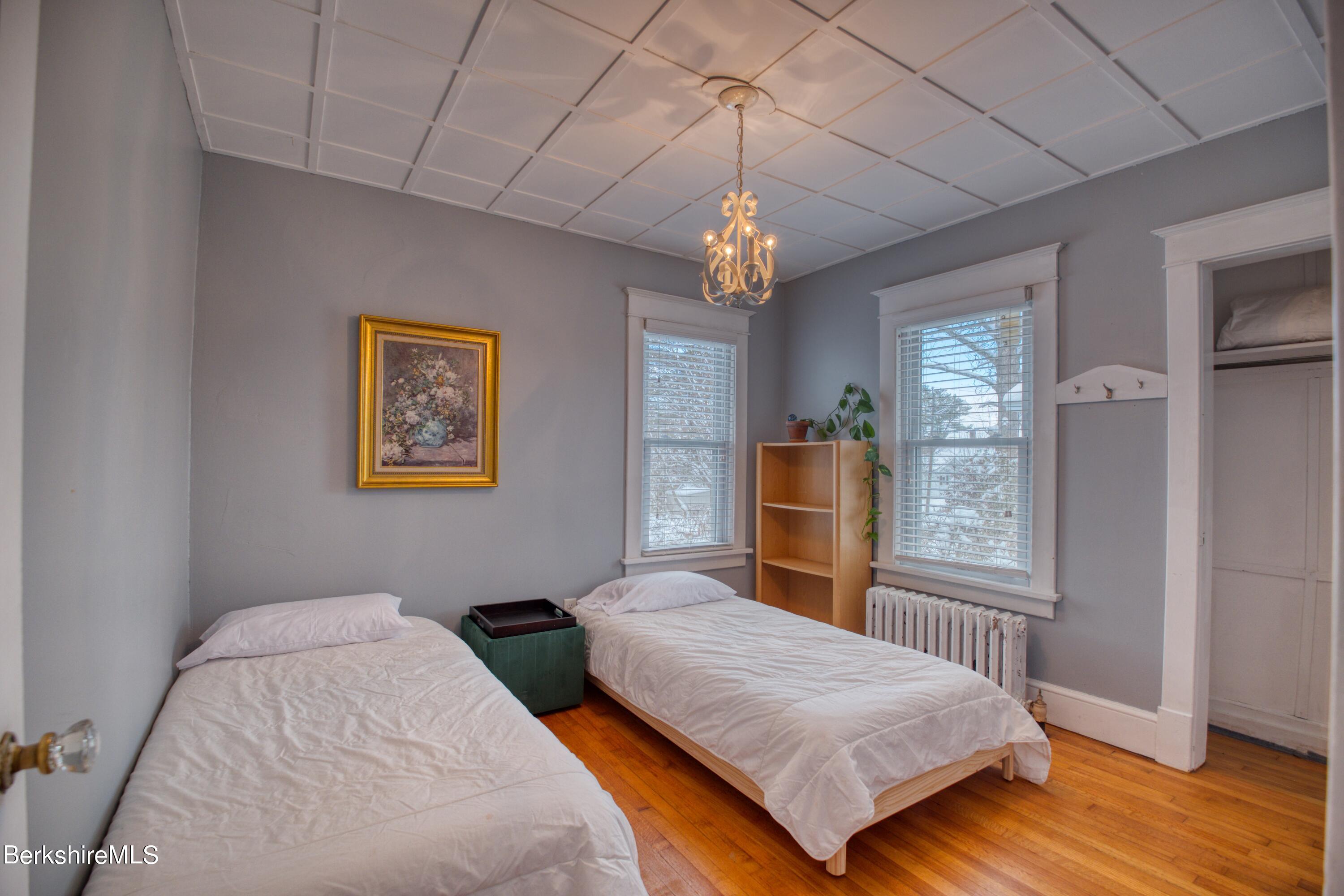39 Catherine Street Pittsfield, MA 01201 - Photo 16 of 26 a bedroom with a bed chandelier and a window