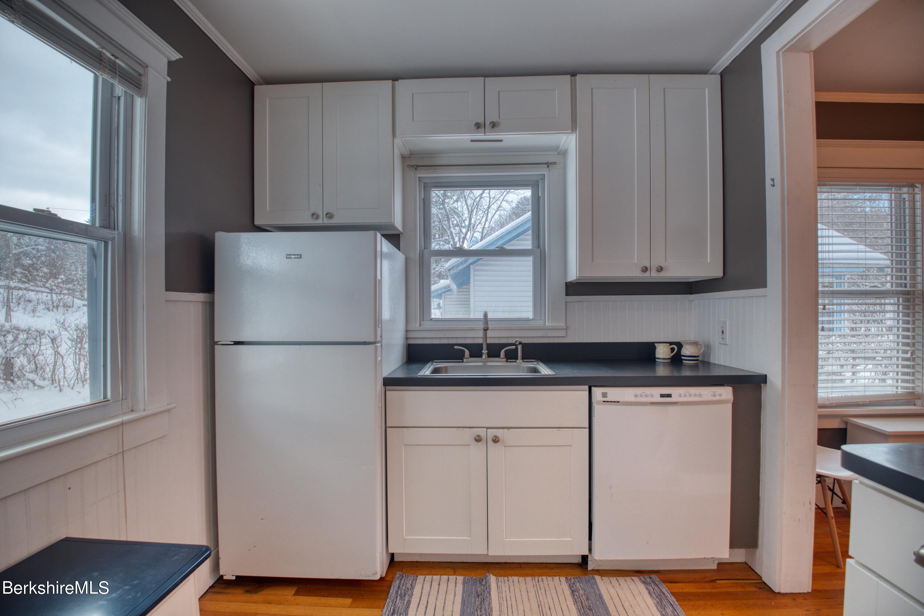 39 Catherine Street Pittsfield, MA 01201 - Photo 22 of 26 a kitchen with granite countertop a refrigerator a sink and white cabinets