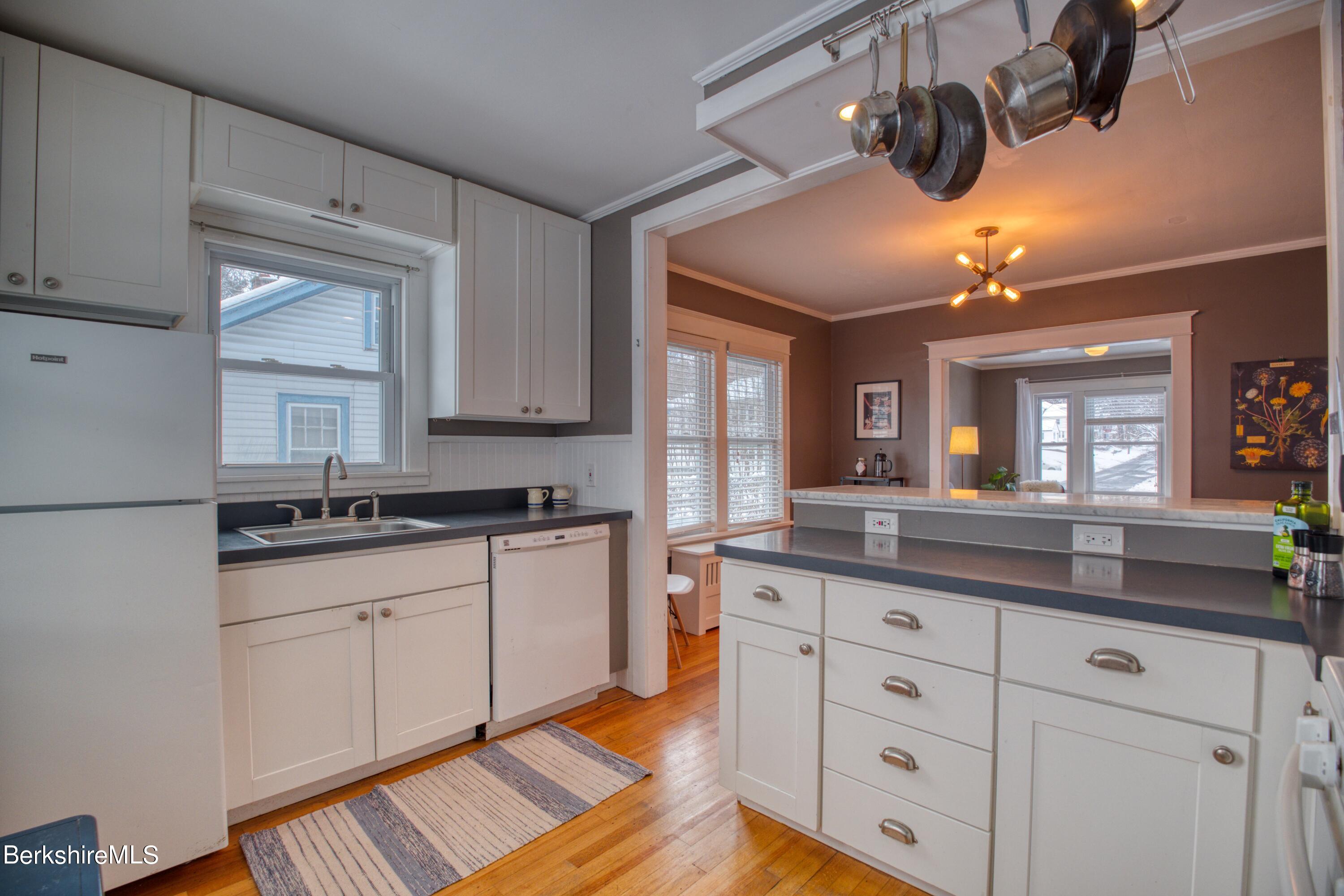 39 Catherine Street Pittsfield, MA 01201 - Photo 23 of 26 a kitchen with granite countertop white cabinets and a wooden floor