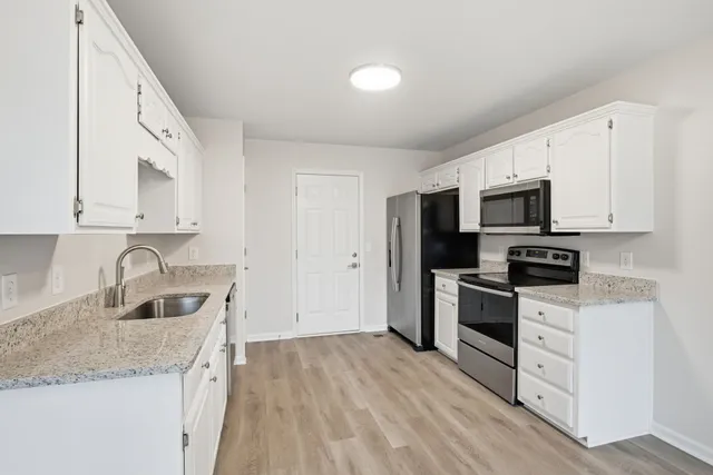 a kitchen with granite countertop a sink and steel appliances