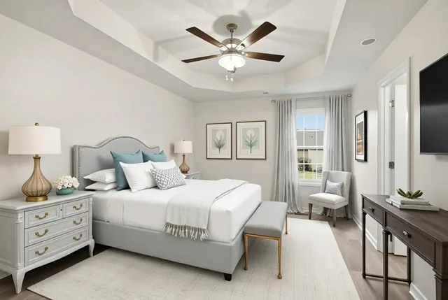 a bedroom with a white bed and ceiling fan