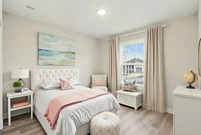 a bedroom with a bed and wooden floor