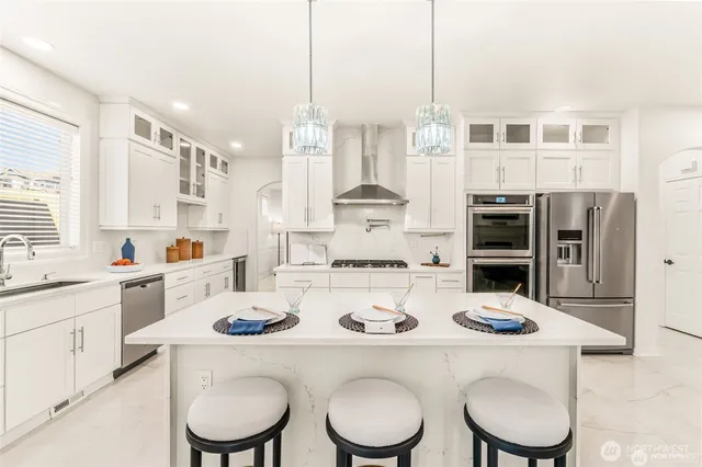 a kitchen with white cabinets and appliances