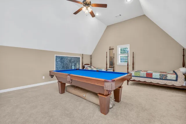a living room with furniture pool table and bed