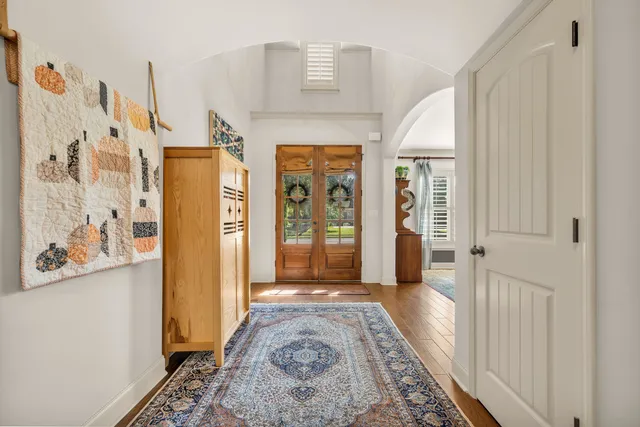 a view of a hallway with wooden floor and a large window
